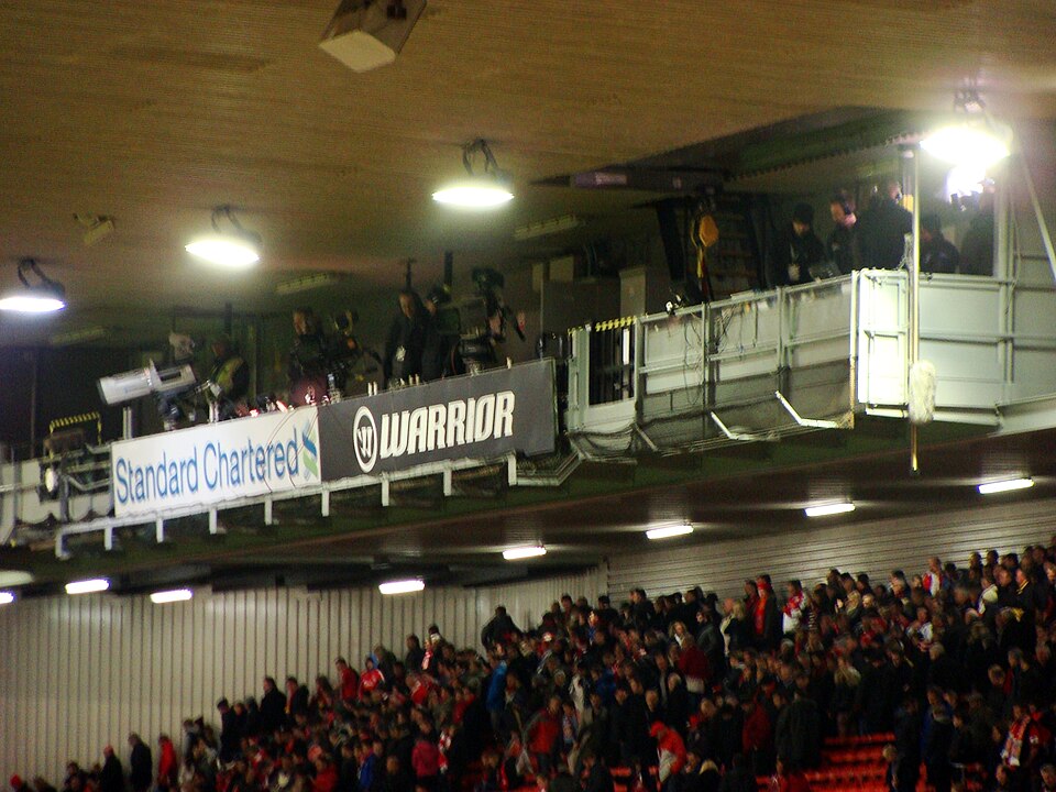 Aficionados en el estadio desplegando un tifo durante un partido de alta rivalidad